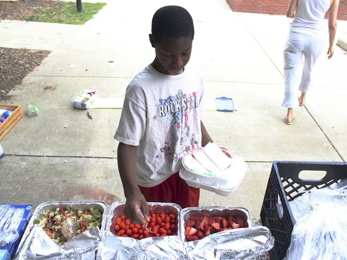Anton Enoch serves himself food during Friday Fun Day, a free lunch event for families in the Chapel Hill area. 