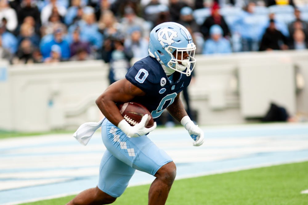 Sophomore defensive back Ja'Qurious Conley (0) runs the ball at the UNC v. Wake Forest game on Saturday, Nov. 6, 2021 at Kenan Stadium. The Tar Heels won 58-55.