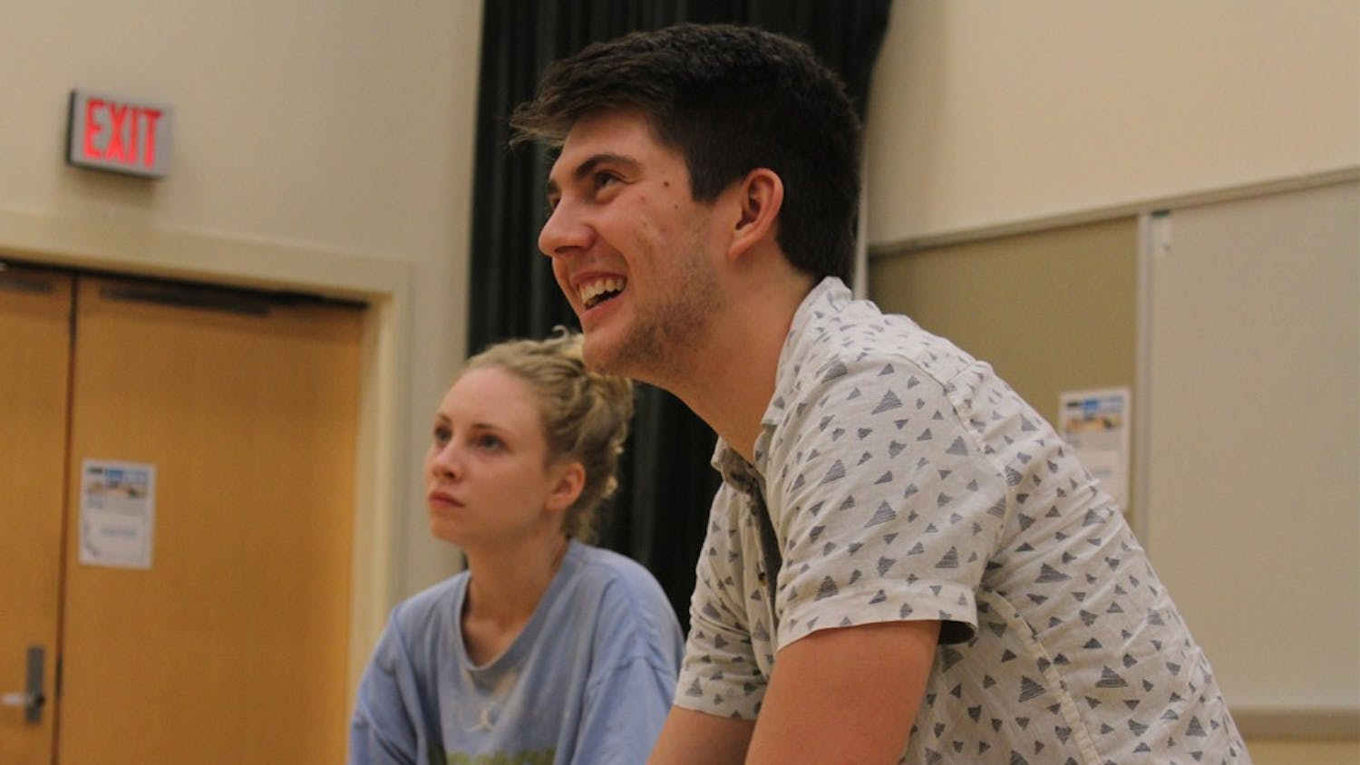 A day in the life of a CHIP: Senior Luke Miller (Business Administration and Economics Major and minor in cognitive science) looks on as his fellow CHIP members practice a skit. Bobby Decker (far left) (junior, English/Political Science Major) and Isabelle DeWitt (center) (senior, dramatic arts major) also look on.