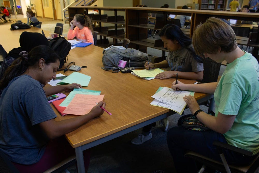 <p>UNC students Anna Monocha, Laurel Thomas, Marina Perez, and Wid Alsadoon work together on a group project before Fall Break in Davis Library on Thursday, Oct. 10, 2019.</p>