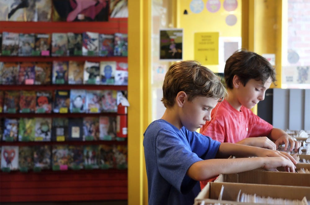 Jake Purves (left) and his brother Trey Purves peruse comic books at Chapel Hill Comics on Franklin Street. Jake has subscriptions to Antman and Secret Wars.