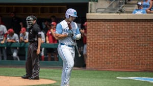 Sophomore designated hitter Alberto Osuna (23) hangs his head as he walks back to the dugout after striking out during UNC's NCAA Super Regional against Arkansas at Boshamer Stadium on Saturday, June 11, 2022.