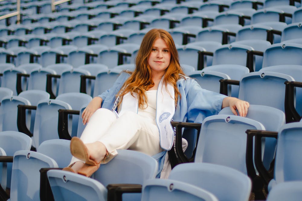 Sophie Swift, a senior computer science major, poses for a portrait at Kenan Memorial Stadium on Wednesday, Apr. 28, 2021. "I want to be true to myself," says Swift, who's opting to wear a jumpsuit to the ceremony. "And dress in a way that really feels like me."