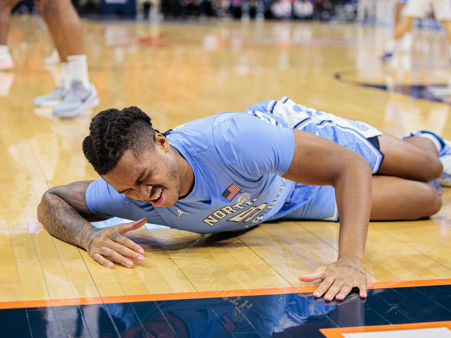 UNC senior Armando Bacot (5) goes down following an injury in the first half during a game against UVA at John Paul Jones Arena in Charlottesville, VA on January 10, 2023. UNC lost 65-58. Photo courtesy of Ryan Hunt.
