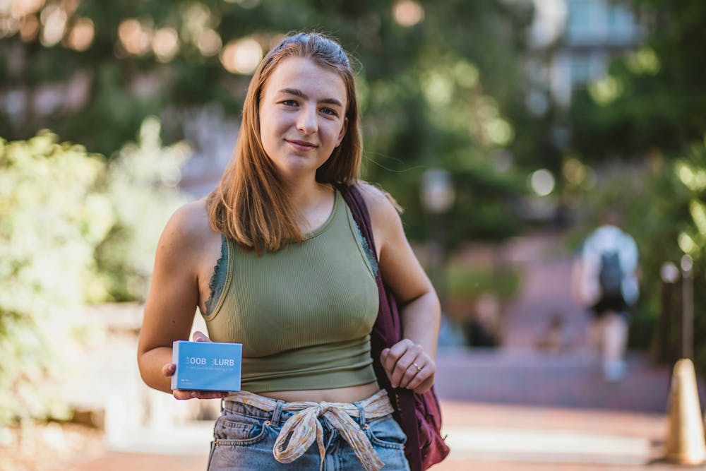 With a backpack and a water bottle, sophomore Izzy Grandic walked around campus for over thirteen straight hours  to raise awareness about inaccessible healthcare. She poses with her card game, Boob Blurb, on Wednesday, Sept. 21, 2022.