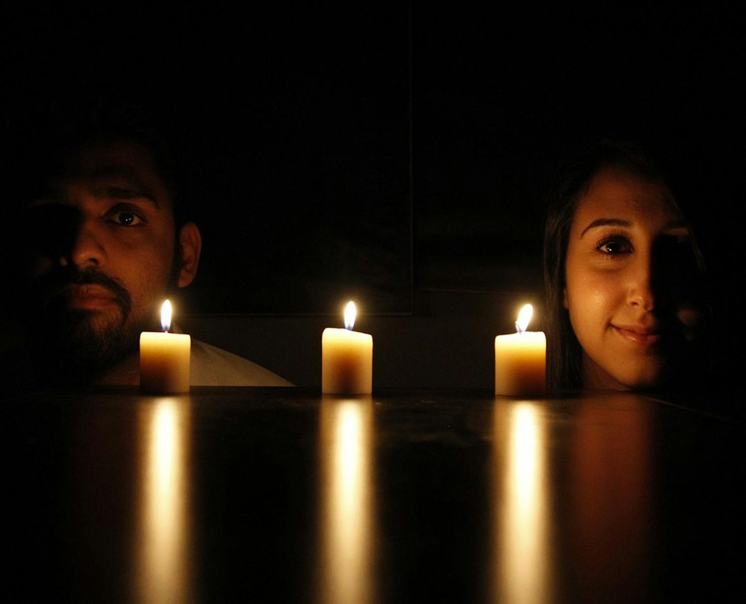 Imad Ahmad (left), Deah's best friend and roommate, and Lina Chaarawi, Yusor and Razan's cousin, pose in front of candles for each of Our Three Winners.