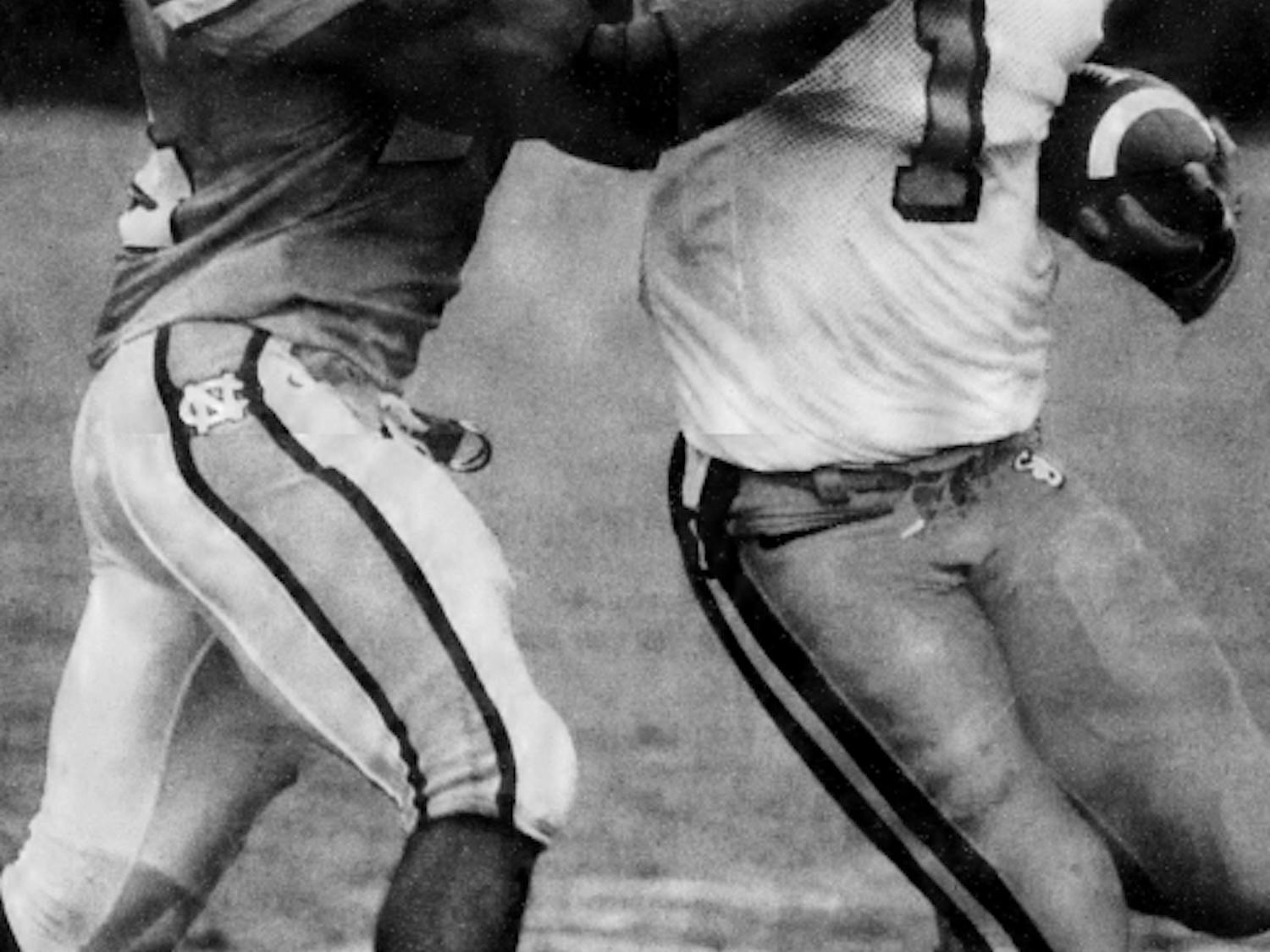 DTH Archive. Syracuse running back Damien Rhodes (1) fights off UNC safety Dexter Reid in the Orangemen's triple-overtime win. Syracuse overcame a 17-point third quarter deficit to tie the game on a field goal. Photo by Kimberly Craven.  