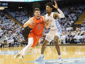 Virginia Tech junior guard Hunter Cattoor (0) attempts to drive past UNC senior forward Leaky Black (1) during UNC basketball's home game against Virginia Tech on Monday, Jan. 24, 2022, at the Dean Smith Center. UNC won 78-68.