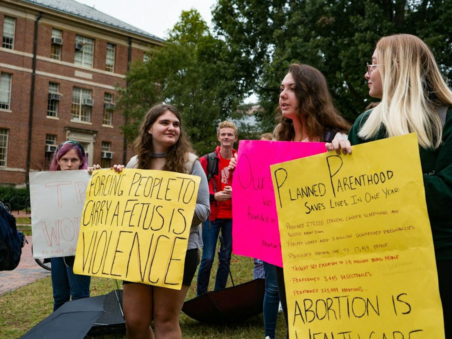 Students protest near the anti-abortion Genocide Awareness Project exhibit displayed at Polk Place on Tuesday Oct. 22, 2019. This exhibit included graphic images and made comparisons between abrotion procedures and mass genocides.