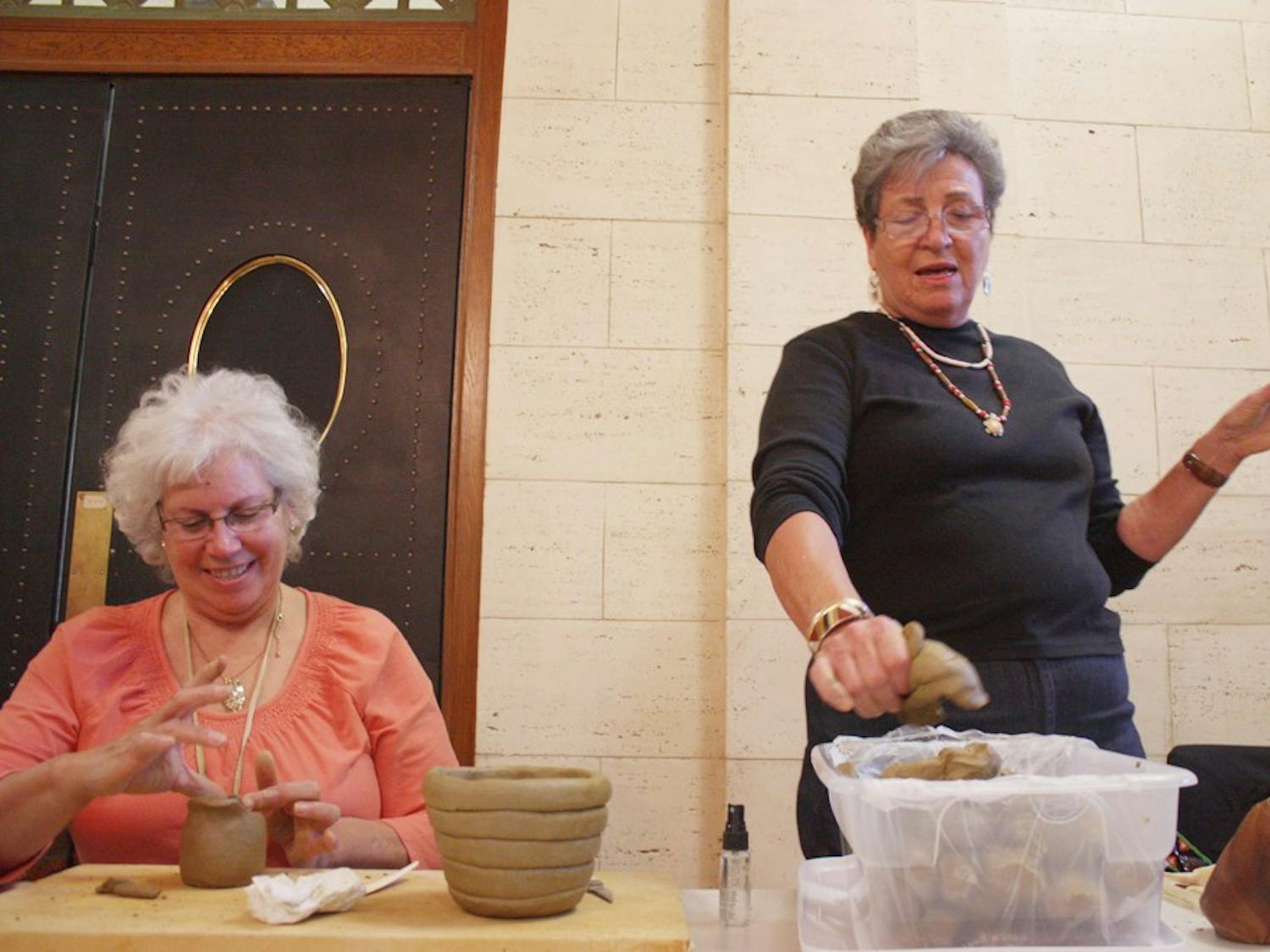 Beckee Garris and Caroleen Sanders conduct a pottery-making demonstration in Wilson Library. The program was part of an event to showcase “Unearthing Native History: The UNC Catawba Archaeological Project.” 