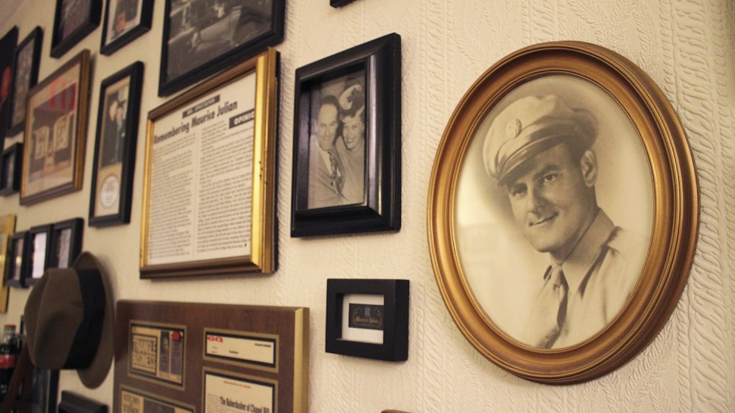 Photos and articles commemorating business leader Maurice Julian (right) and his family hang on the back wall in Julian’s on Franklin Steet.