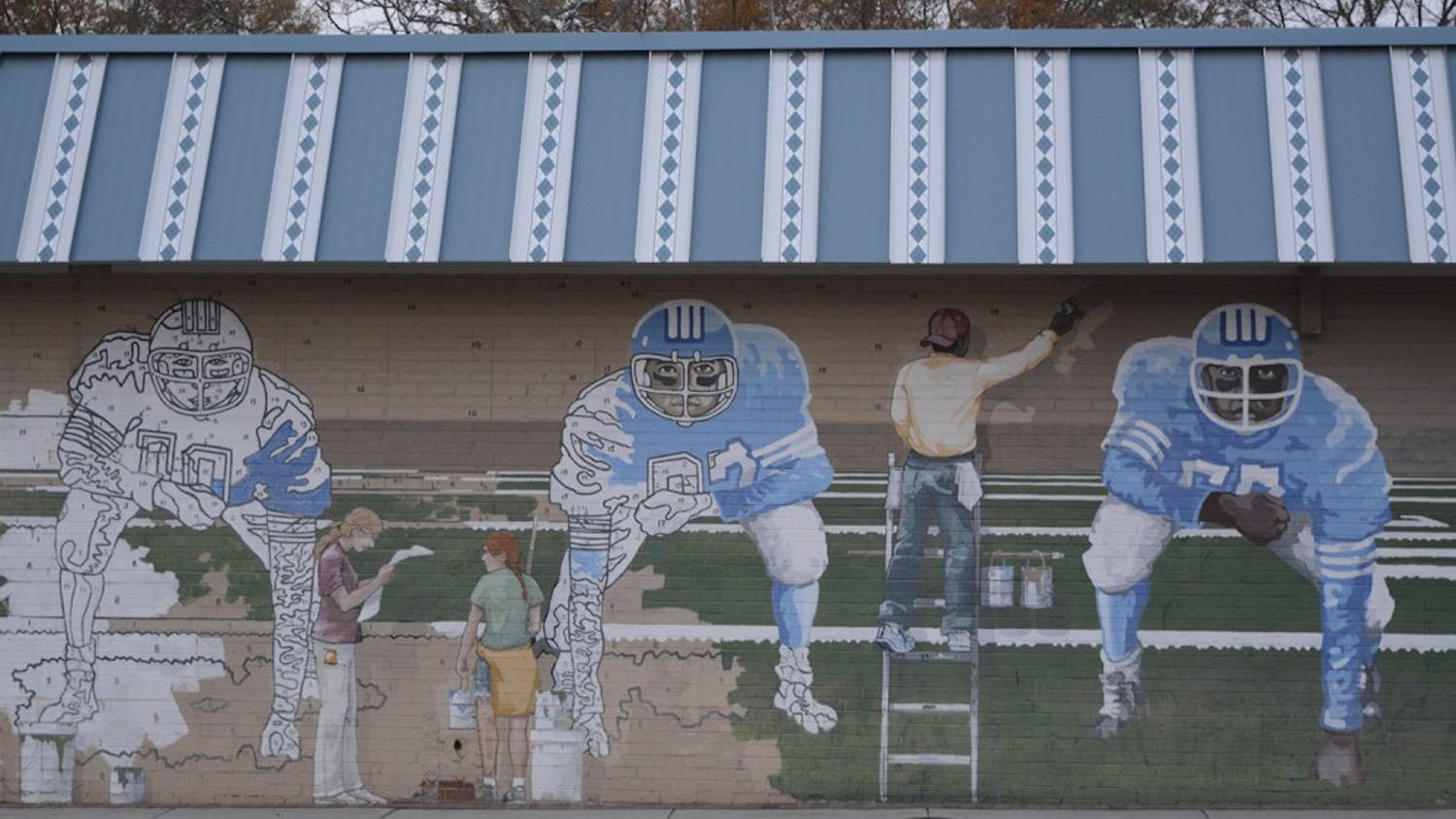 The paint-by-number mural features UNC football players and is located on the side of Pantana Bob's. 