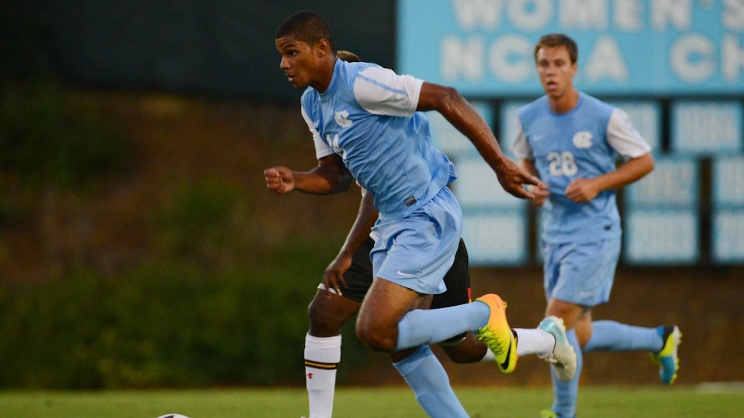 UNC midfielder Omar Holness (14) dribbles the ball up the middle of the field.