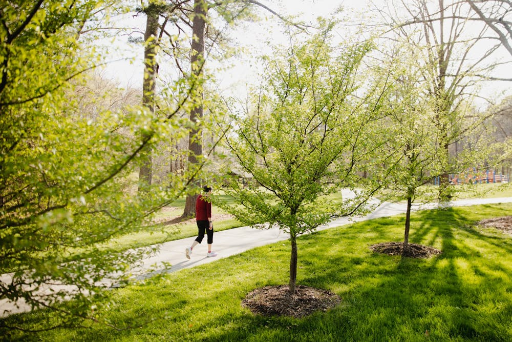A woman walks down a path in Umstead Park by the Bolin Creek Trail on Monday, April 4, 2022.