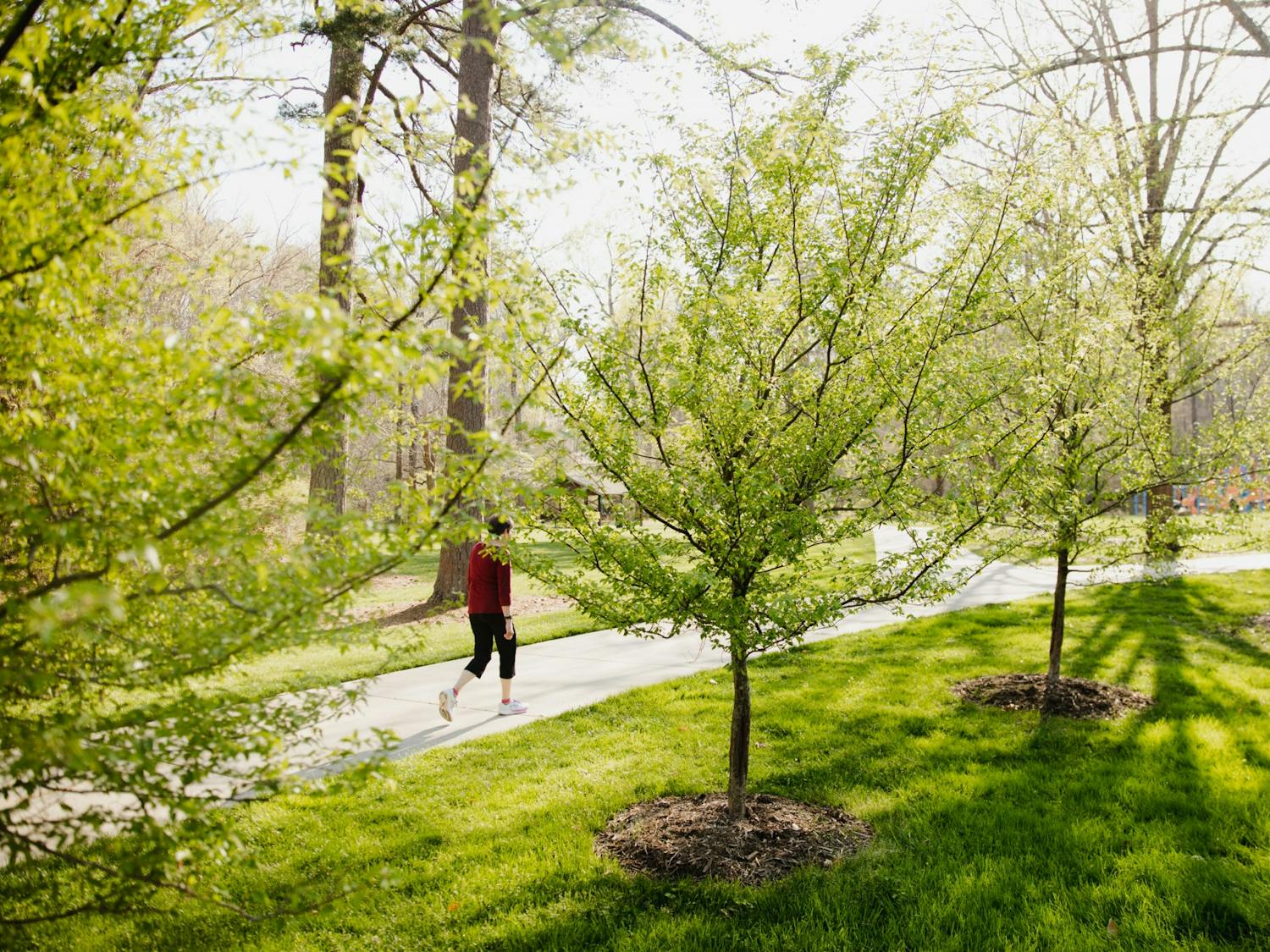 A woman walks down a path in Umstead Park by the Bolin Creek Trail on Monday, April 4, 2022.