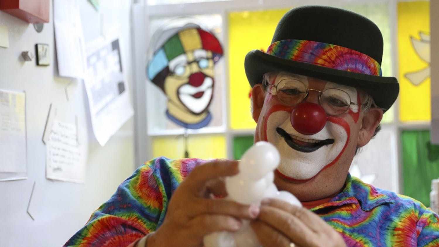 David Bartlett aka Mr. Rainbow the clown makes a balloon animal in his home in Durham.