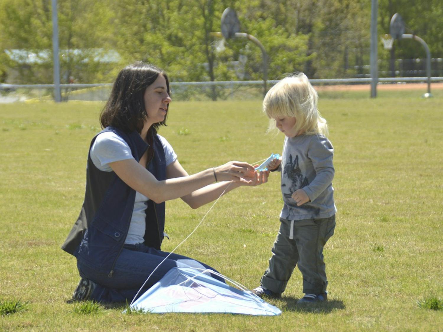 Carrboro Kite Fly takes place on Sunday Apr.17  from 1PM to 3 PM at Hank Anderson Park. Andrea Wood (left) from Carrboro is teaching her two-year-old son Rye Jones(right) to fly a kite. 