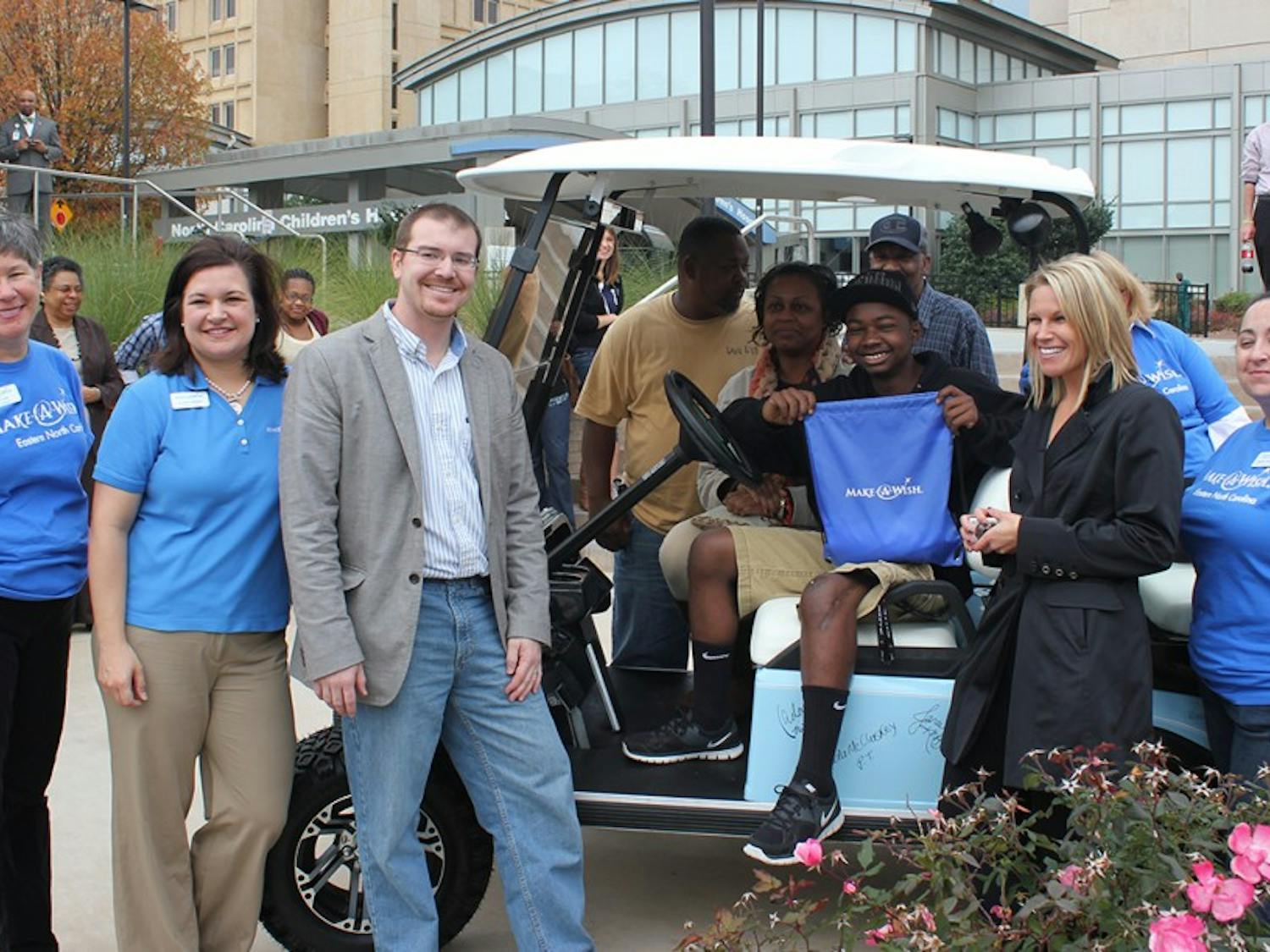 On Friday bone cancer survivor Kzon Crenshaw, pictured with his family and team, received a custom Carolina blue golf cart signed by the people who supported him through his illness. In describing the people behind the signatures Crenshaw said, "They're my superstars."