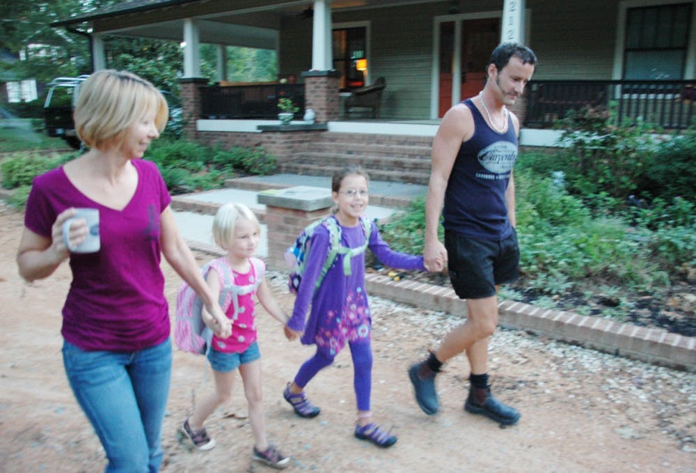 Cathy, six year old Rachel, seven year old Isabella and Cray Gun walk to Carrboro Elementary School from their house on Hillsborough street  on Thursday morning. Their house was picked up and relocated and Mr. and Mrs. Gunn worried about the reduction of privacy if a road for the library  was built adjacent to their house. 
