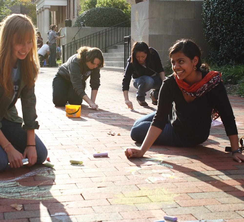 Sophomore business major Jess Hetzel (left) and sophomore international studies major Mitali Dayal participate in Chalking Sidewalks.
