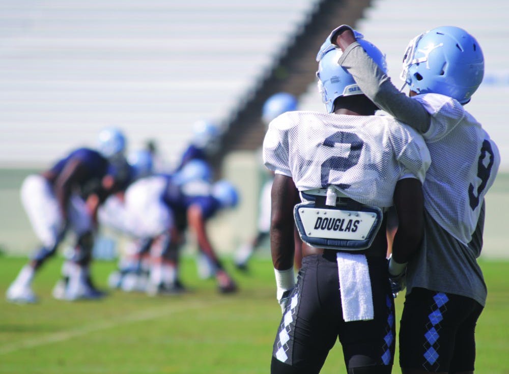 UNC football players watch their teammates from the sideline during team practice on Aug. 21.&nbsp;