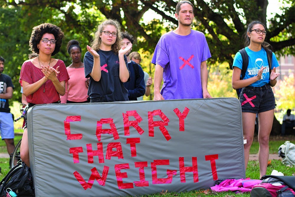 Student protesters from the "Carrying the Weight Together," a national effort to bring awareness to sexual assault injustice at colleges,  applaud speeches given at the Wainstein Rally. 