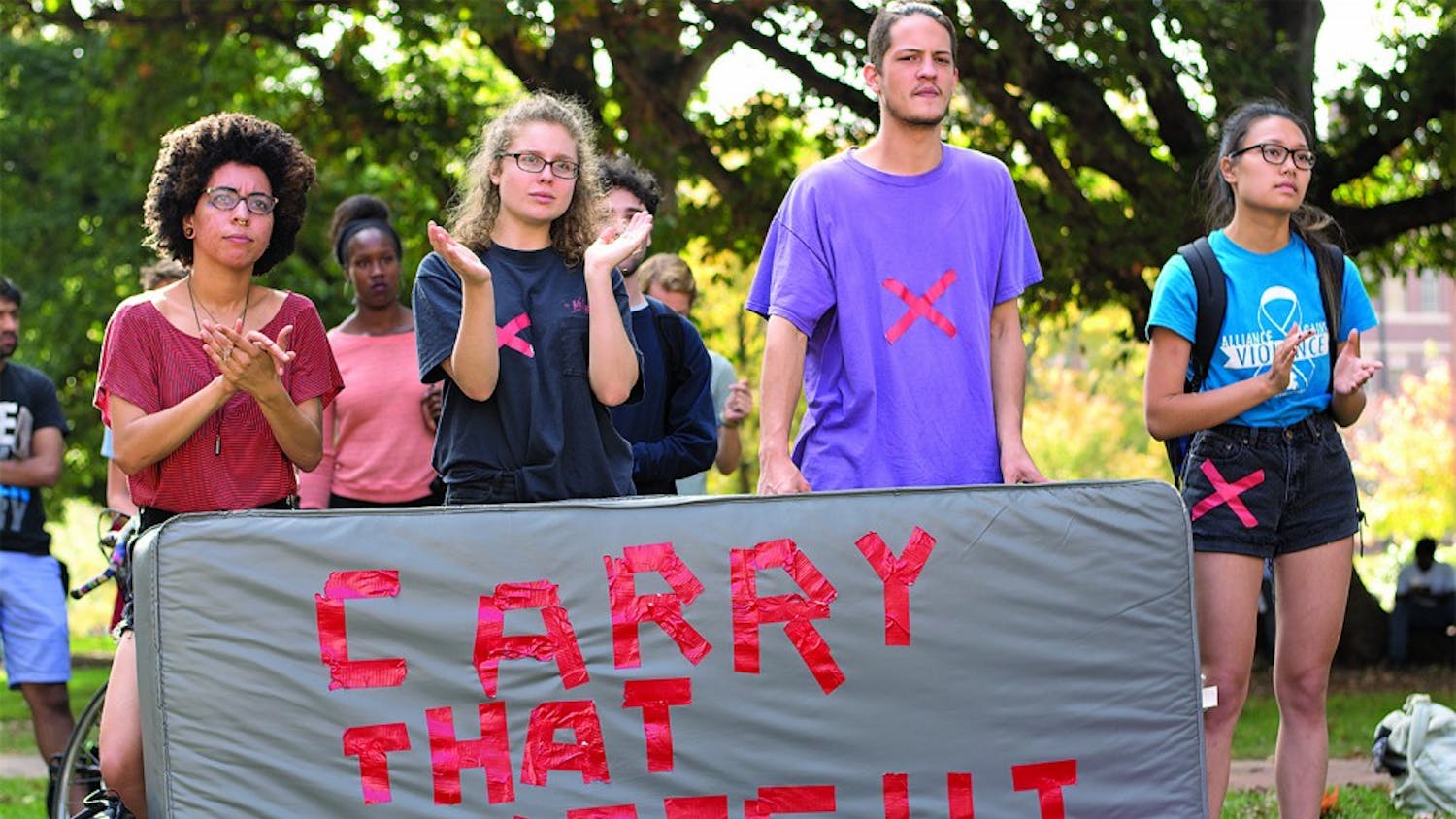 Student protesters from the "Carrying the Weight Together," a national effort to bring awareness to sexual assault injustice at colleges,  applaud speeches given at the Wainstein Rally. 
