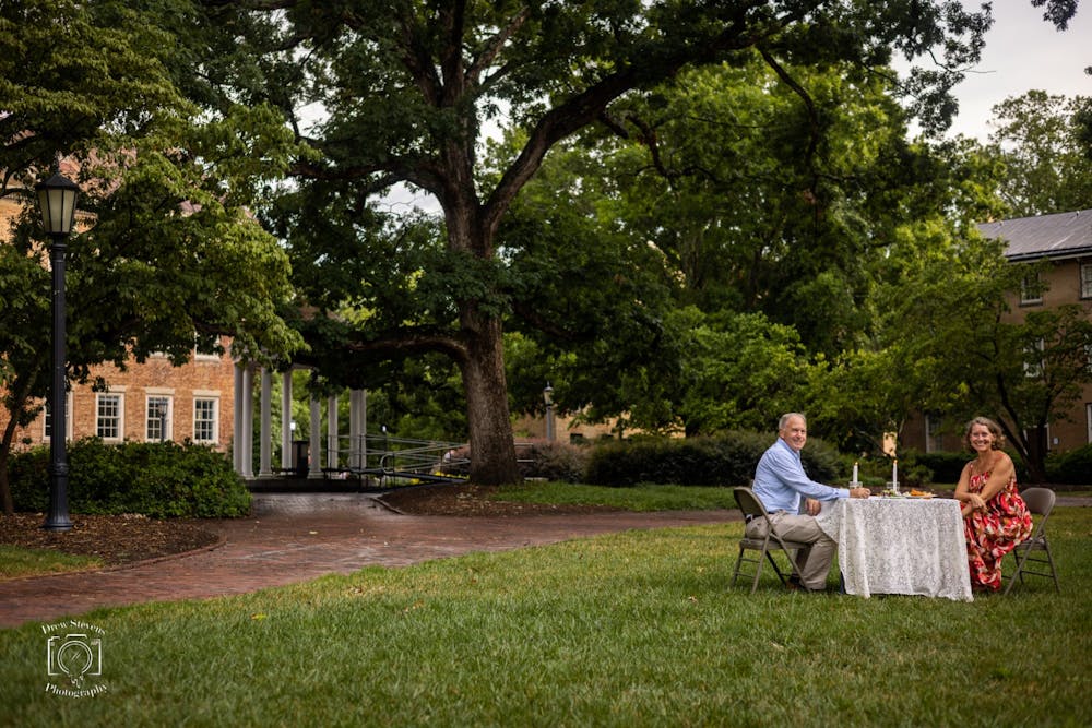 <p>Nancy and Tucker Stevens share a meal in front of the Old Well on July 7, 2022 to celebrate the anniversary of their engagement. Tucker proposed to Nancy 32 years ago in the same spot. Photo by Drew Stevens.</p>