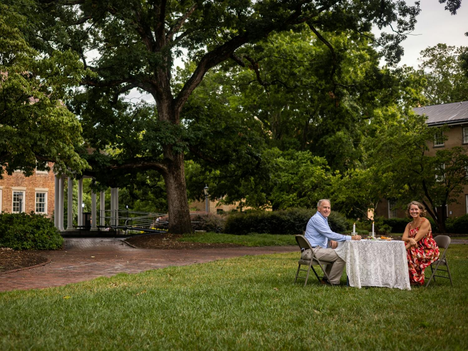 Nancy and Tucker Stevens share a meal in front of the Old Well on July 7, 2022 to celebrate the anniversary of their engagement. Tucker proposed to Nancy 32 years ago in the same spot. Photo by Drew Stevens.