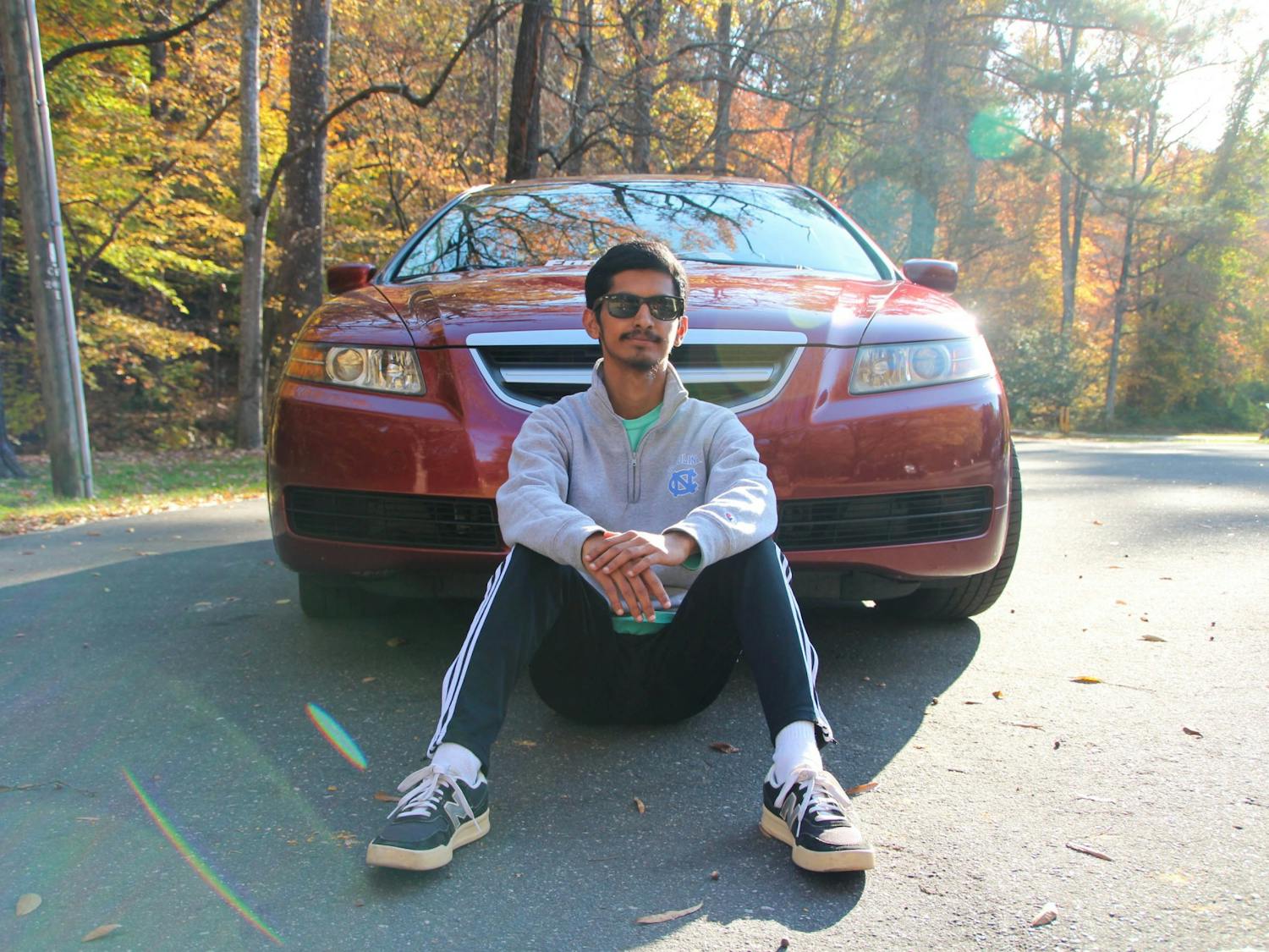 UNC junior and Carolina Car Club president Sachith Iyengar poses with his Acura at Umstead Park on Nov. 17.