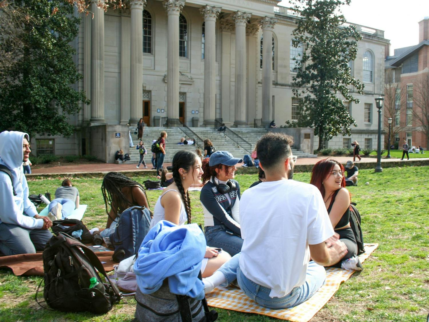 UNC students sit in Polk Place and enjoy the warm weather on Monday, Feb. 21, 2023.