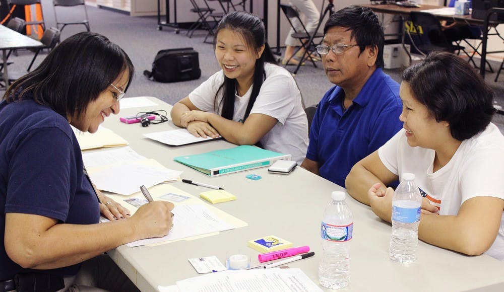 Hnin Wai and Myint and Aye Thaung attend the Disaster Assistance Center set up in University Mall this week. 