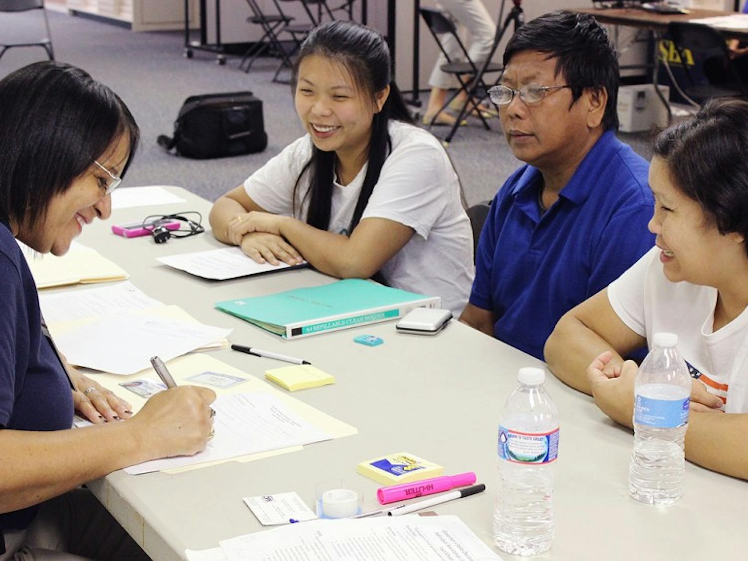 Hnin Wai and Myint and Aye Thaung attend the Disaster Assistance Center set up in University Mall this week. 