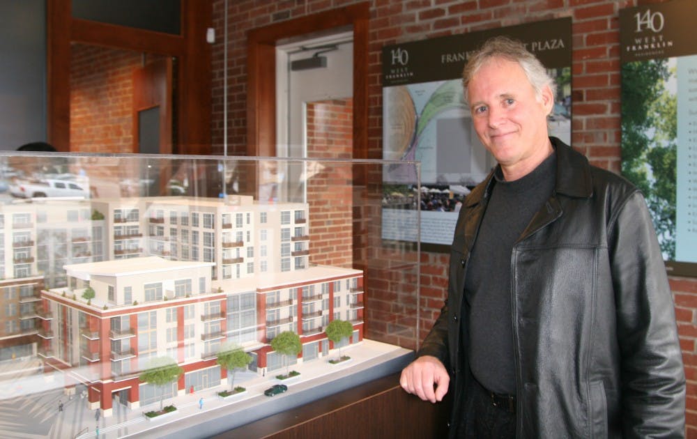 Bill Spiegel, a Chatham County resident and new 140 West Franklin homeowner, stands in front of a showroom model of the development. Spiegel said he values the downtown location of the complex.