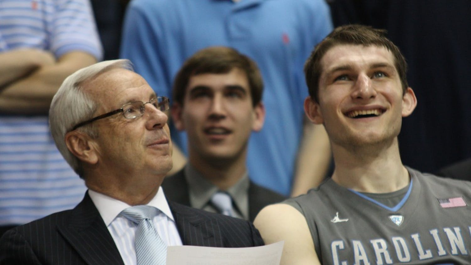 Coach Roy Williams and Tyler Zeller laugh while watching the senior video after the game