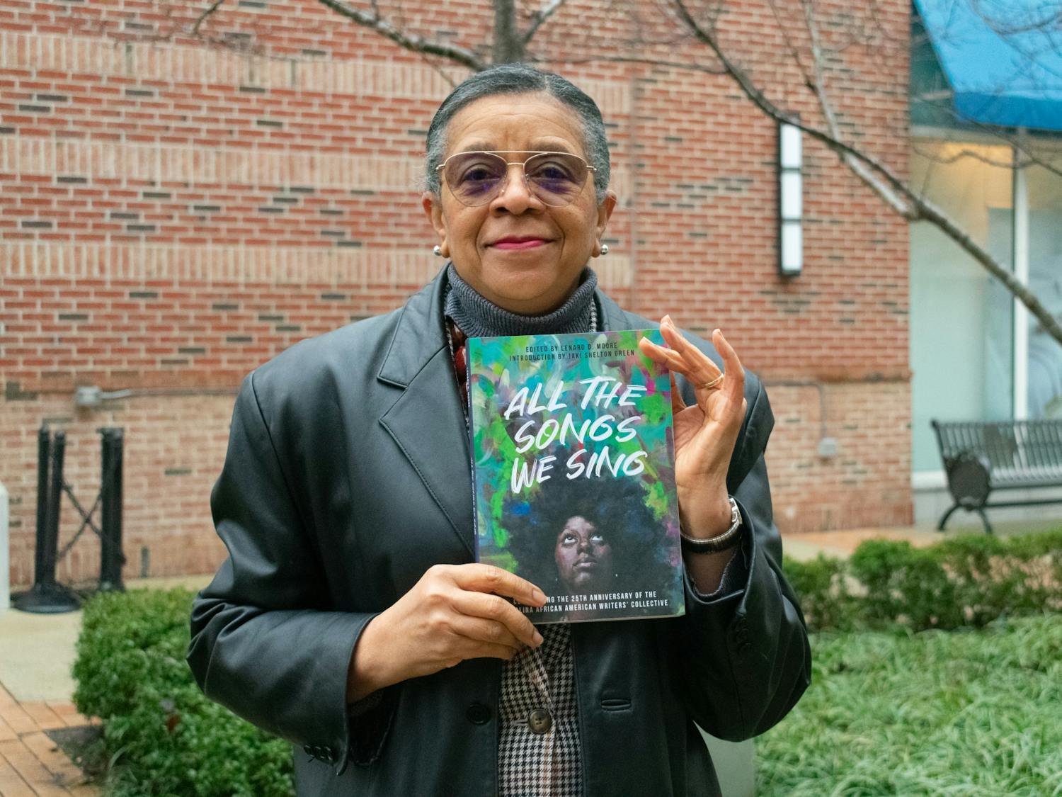 The Carolina African American Writers' Collective was founded in 1995; four members of the group read from the newly released anthology "All The Songs We Sing" on Tuesday, February 9th, 2021. Here, L. Teresa Church stands with a copy of the anthology.