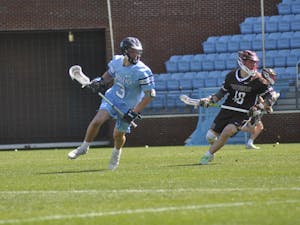UNC senior face-off midfielder Andrew Tyeryar (3) carries the ball across the field during the men's lacrosse game against Brown at Dorrance Field on Saturday, March 11, 2023. UNC won 19-6.