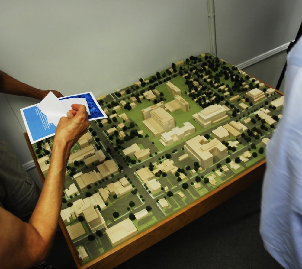 Concerned residents look at a model of the proposed University Square development at a meeting on Thursday, Aug. 19 at University Square.
