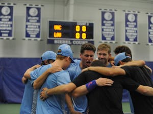 The UNC men’s tennis team huddles together at the ACC tournament quarterfinals. UNC played against Louisville and won 4-0.