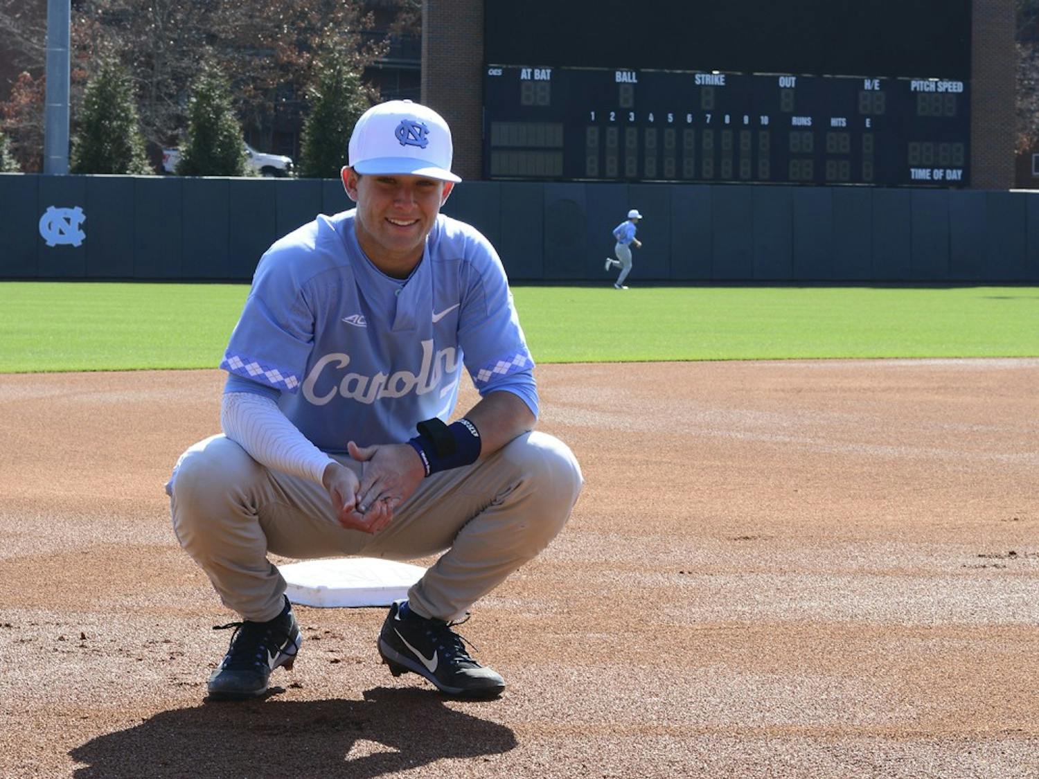 Former UNC shortstop Logan Warmoth grabs some clay in front of the scoreboard at Boshamer Stadium in Chapel Hill.