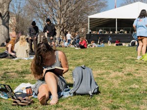 Senior Bella House takes notes in the sun on the Quad on Monday, Feb. 21, 2022.