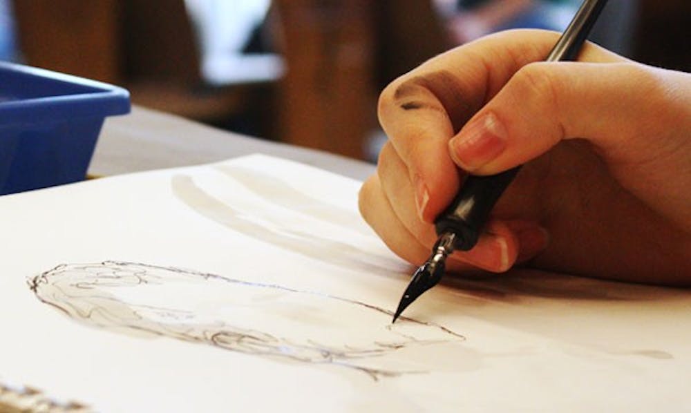 A student draws during a life drawing class in the Hanes Art Center.