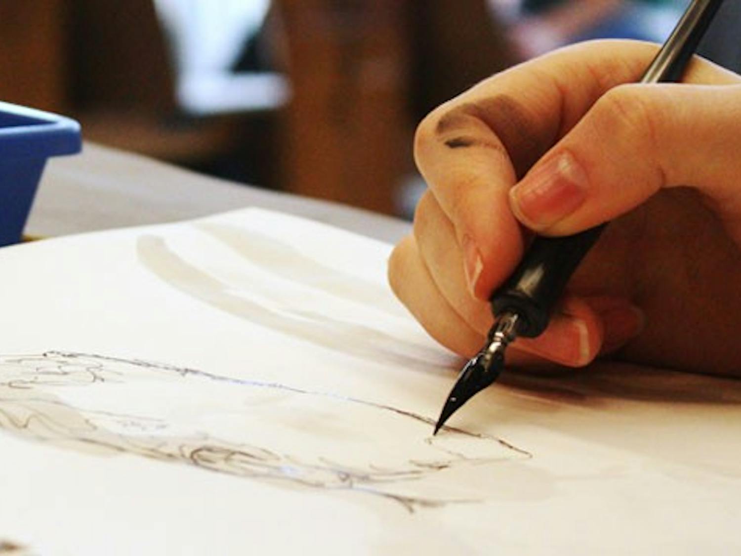 A student draws during a life drawing class in the Hanes Art Center.