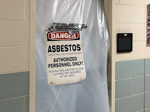 A sign outside of a classroom gives a warning of asbestos in Mitchell Hall in early March, 2023. Photo Courtesy of Sam Vavra.