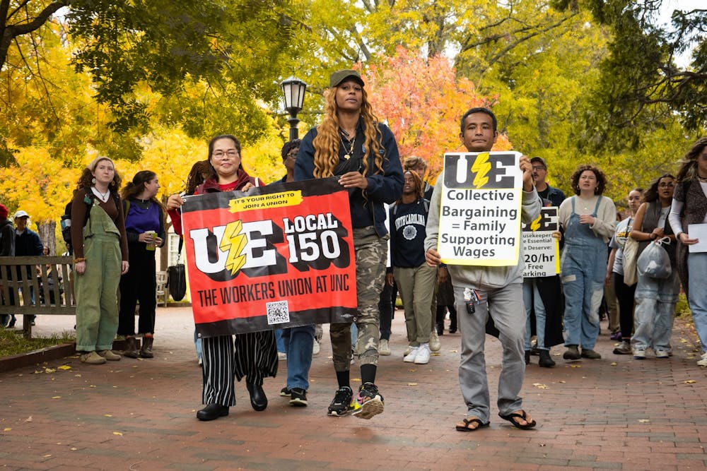 UNC housekeepers march with posters during the UNC Housekeepers March & Rally on Oct. 28, 2022.