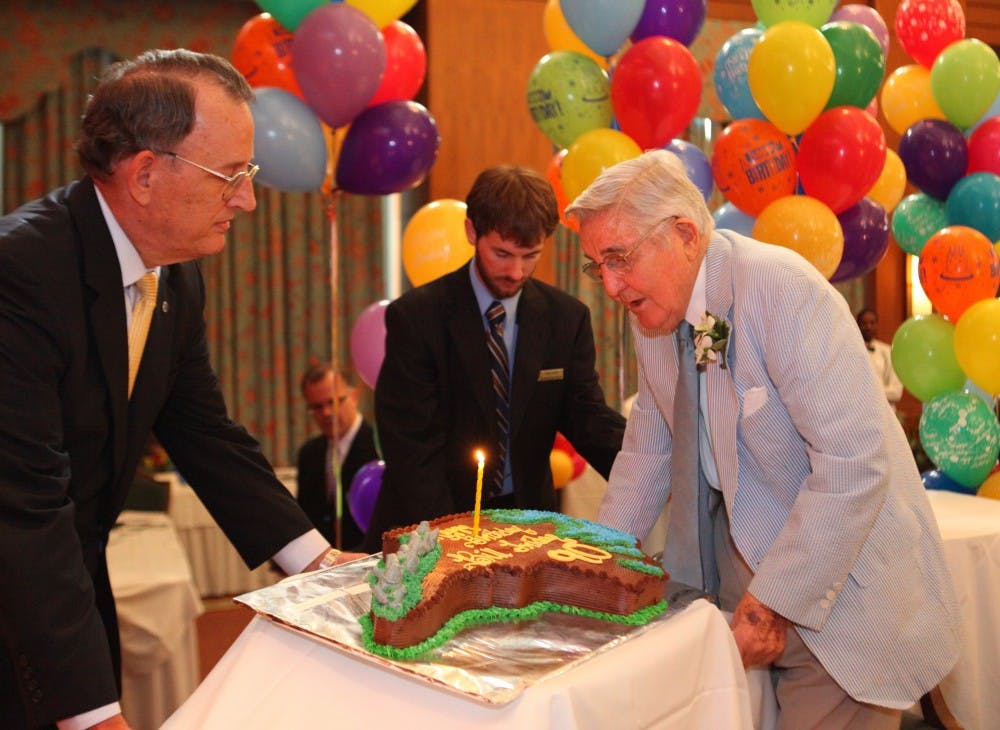 Former UNC system president Bill Friday blows the candle out on his cake at the his 90th birthday celebration Tuesday. The event, held at the Carolina Club at the Hill Alumni Center, was open to the public. 