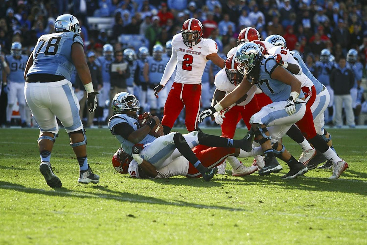 Junior quarterback Marquise Williams (12) is sacked by N.C. State defensive tackle T.Y. McGill (75). The Tar Heels lost 35-7 to the Wolfpack on Saturday.