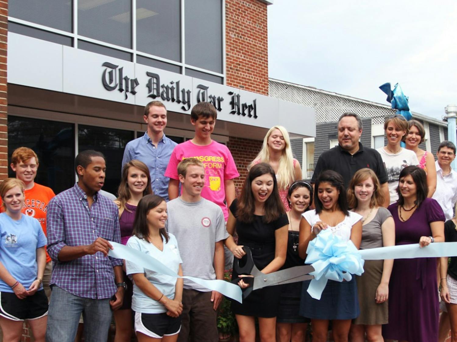 Sarah Frier, editor-in-chief of The Daily Tar Heel, cuts a ribbon to commemorate the newspaper’s new office on East Rosemary Street. The DTH moved in June to its new location from the Frank Porter Graham Student Union.
