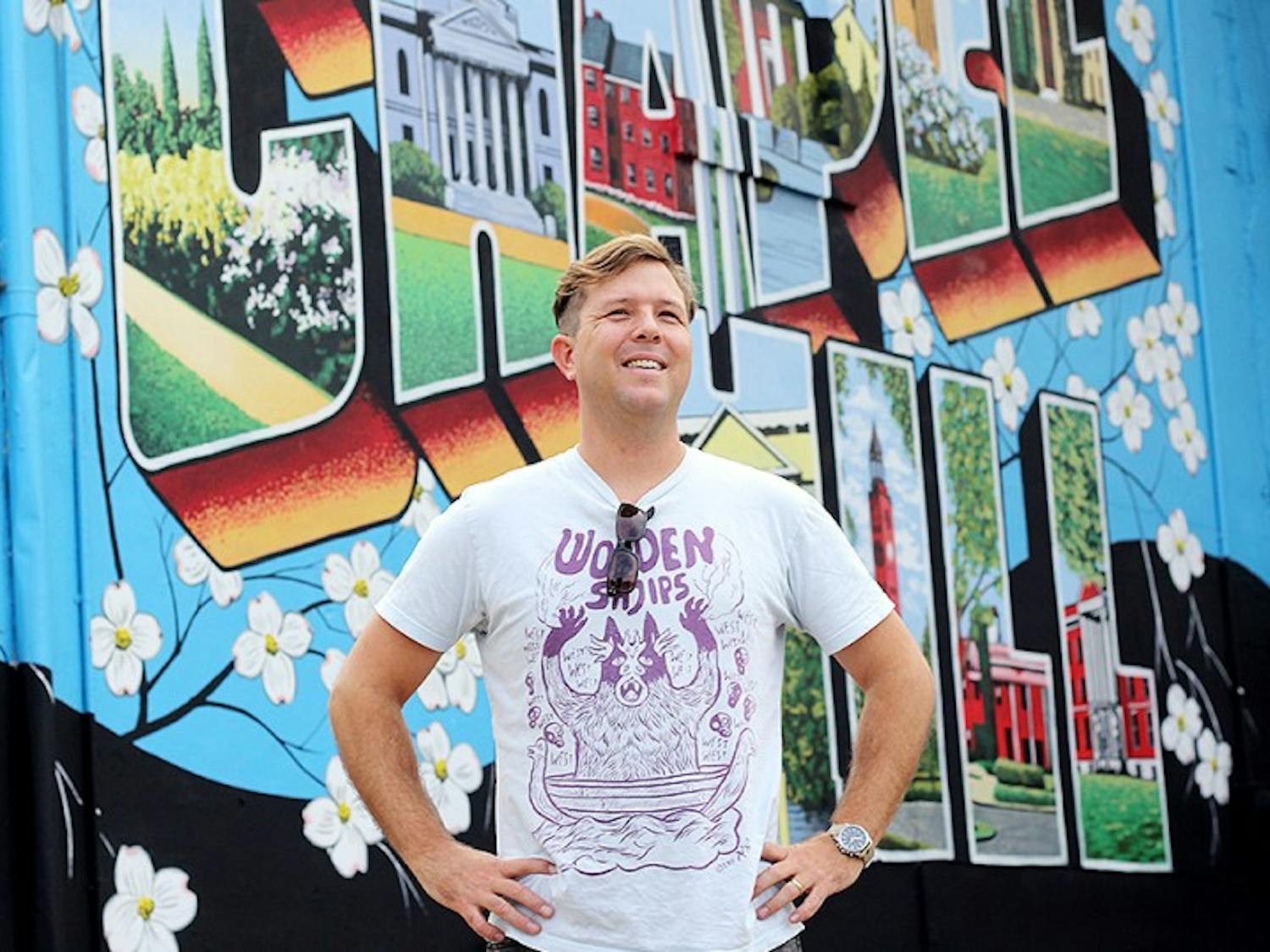 Scott Nurkin alongside his newest mural at He's Not Here