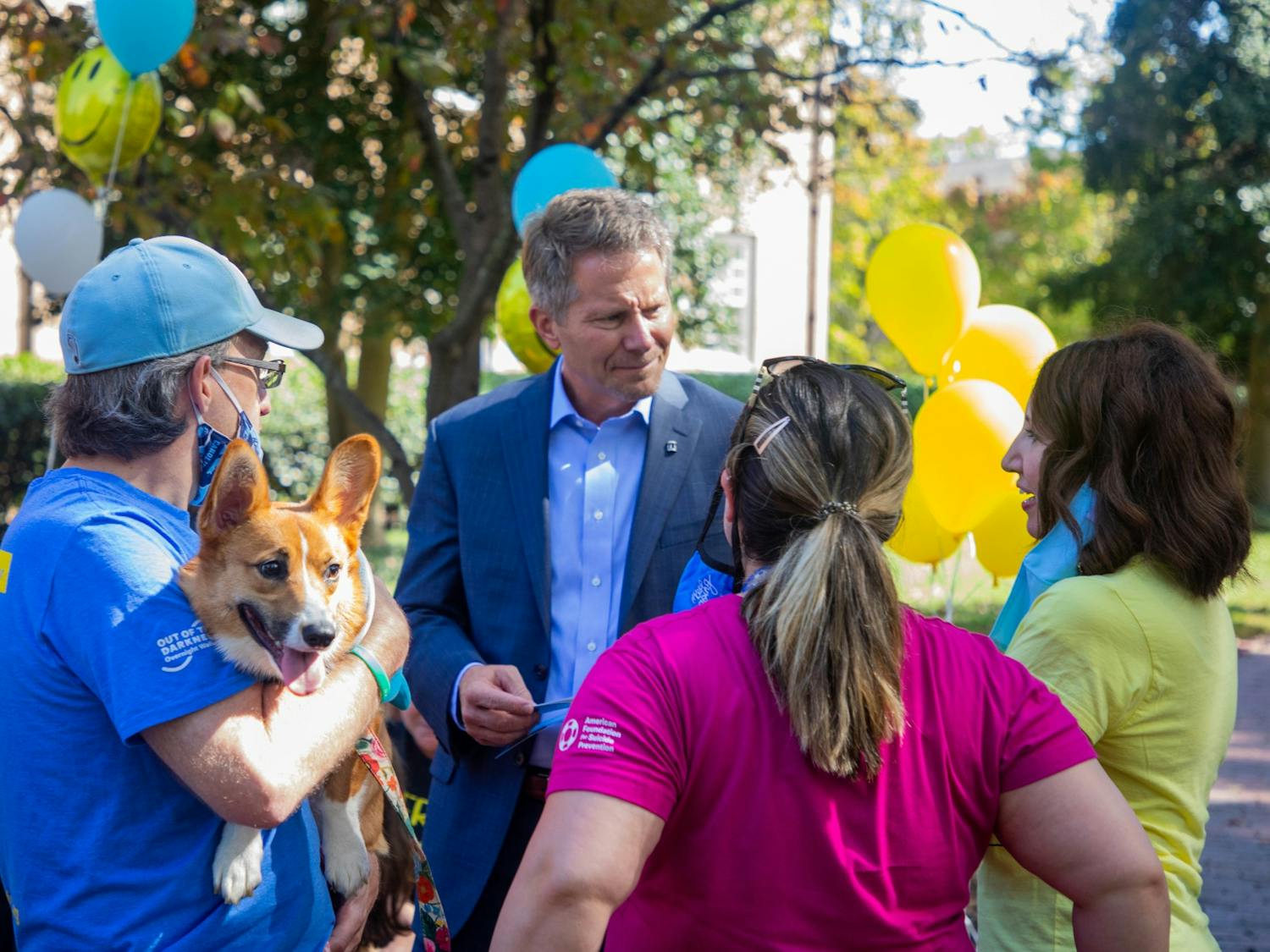 UNC Chancellor Kevin Guskiewicz greets parents, students and puppies near the Old Well on Thursday during the parent rally organized by the Facebook group UNC-CH Parents Helping Parents. Parents and puppies filled the upper quad to offer hugs, baked goods and support.